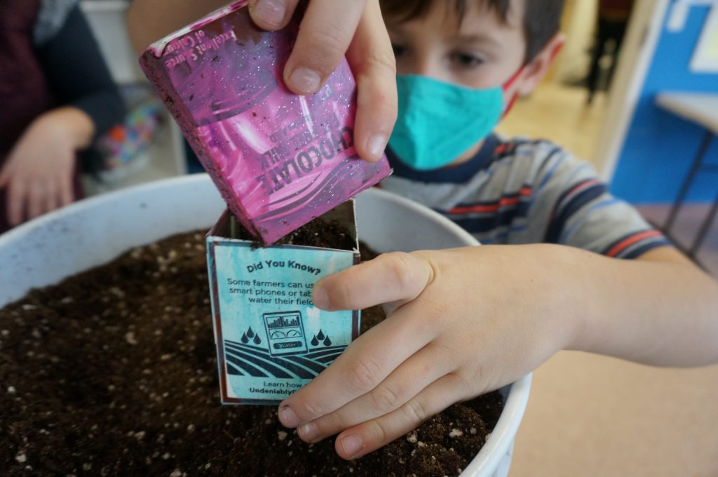 students pouring soil