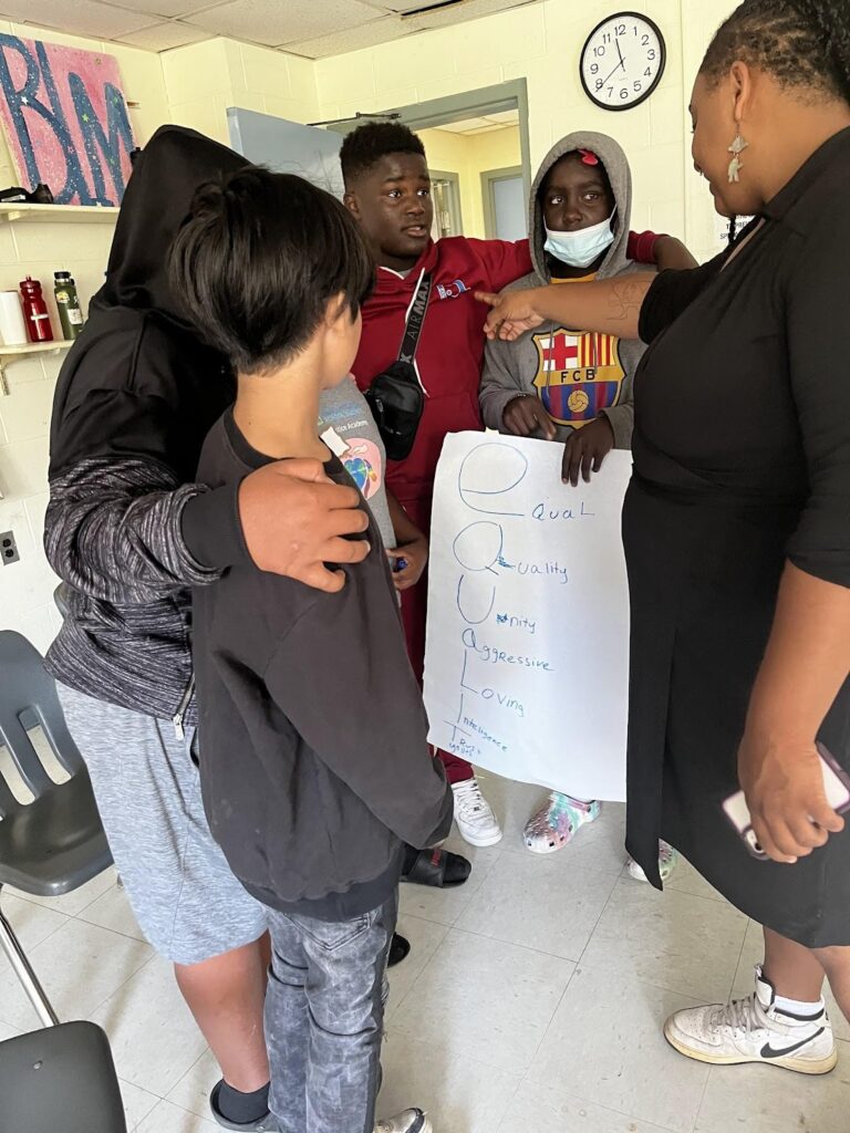 students around chart paper with the word "Equality"