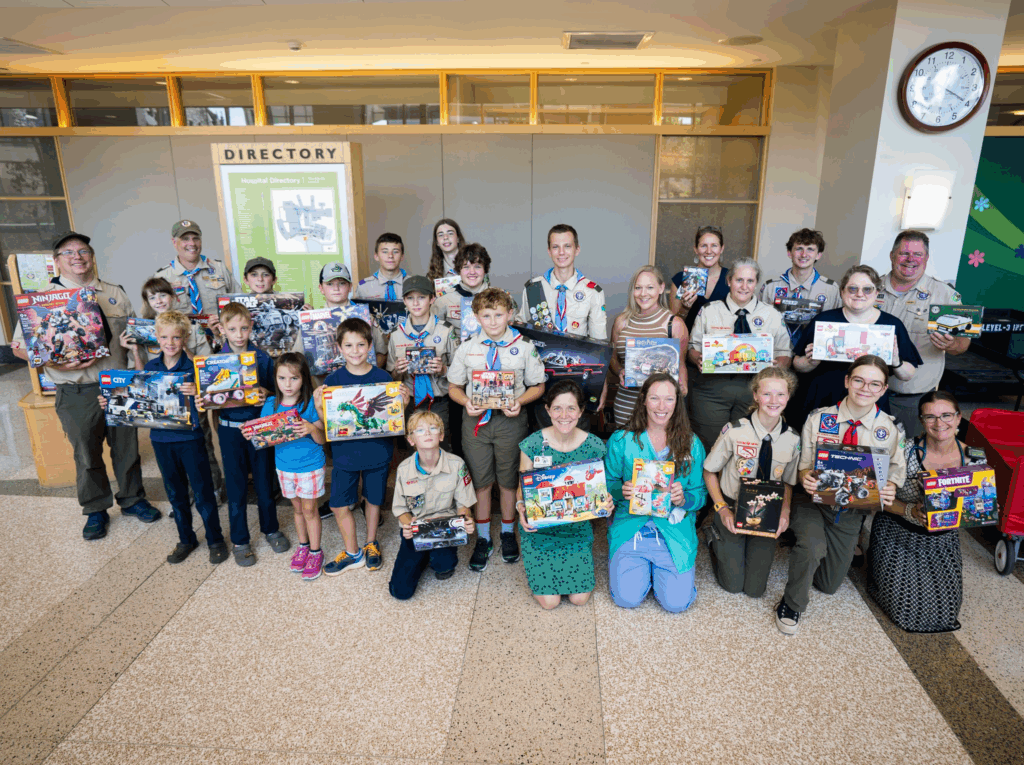 Scouts posing with the boxes of legos being donated