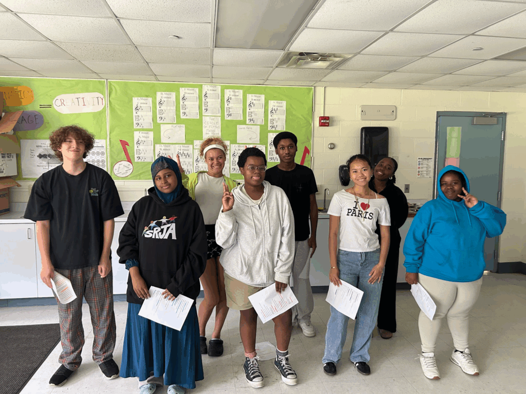 students with papers in front of them posing
