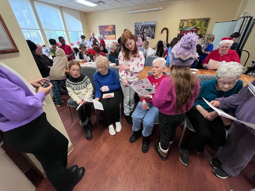 elementary students singing to seniors in a nursing home